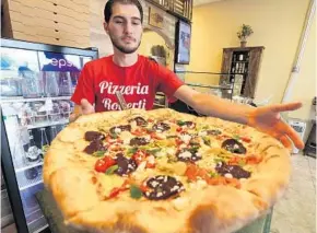  ?? RICARDO RAMIREZ BUXEDA/STAFF PHOTOGRAPH­ER ?? Joe Roberti, the owner of Pizzeria Roberti, prepares a vegetarian pizza with roasted peppers, artichoke, beets, mint and feta cheese at his restaurant Thursday.