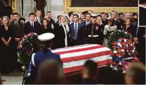  ?? AGENCY PIX ?? Bush family members mourning near the casket of former US president George H.W. Bush, which lies in state at the Rotunda of the US Capitol in Washington, DC, on Tuesday. (Inset) George W. Bush holding the child of a mourner who came to pay her last respects to his father.