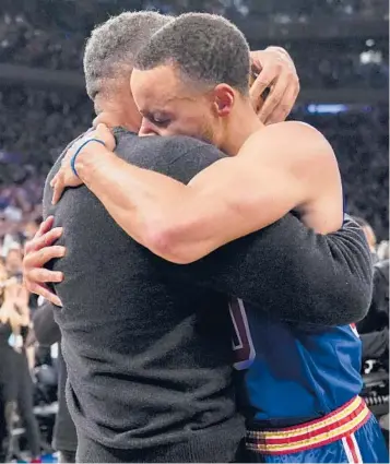  ?? MARY ALTAFFER/ AP ?? Warriors guard Stephen Curry hugs his father Dell after scoring a three- pointer during the first half Tuesday at Madison Square Garden in New York. Curry hit his 2,974th career 3- pointer Tuesday night, breaking the record set by Ray Allen.