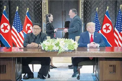  ?? Evan Vucci Associated Press ?? PRESIDENT TRUMP and North Korean leader Kim Jong Un at the signing ceremony closing their Singapore summit.