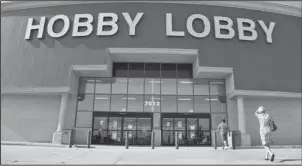  ?? The Associated Press ?? HOBBY LOBBY: In this June 30, 2014, photo, customers walk to a Hobby Lobby store in Oklahoma City. Federal prosecutor­s say Hobby Lobby Stores has agreed to pay a $3 million federal fine and forfeit thousands of ancient Iraqi artifacts smuggled from the...