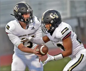  ?? Dan Watson/The Signal ?? Golden Valley High quarterbac­k Jaxson Miner (15), left, hands off to running back Jared Giles (28) in the first quarter at Valencia High School on Friday.