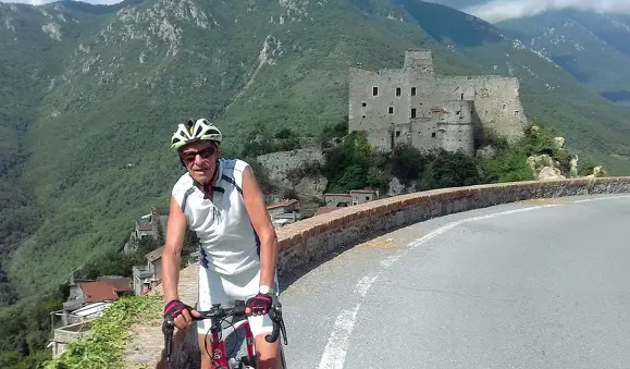  ?? Avveture ?? Pier Roberto Dal Monte, autore di «Una vita in sella», su una strada della Liguria. Sullo sfondo la Rocca barbena