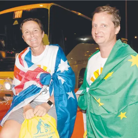  ?? Pictures: MIKE BATTERHAM ?? Leona Adams and Kerry Richards from the Sunshine Coast waiting for a bus after the opening ceremony.