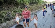  ?? [AP PHOTO] ?? Central American migrant Silvia holds on to her daughters, Karen, 5, left, and Beiyi, 4, while walking with a caravan headed toward to the U.S.