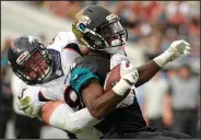  ?? AP PHOTO ?? Jacksonvil­le Jaguars running back T.J. Yeldon, right, is stopped by Denver Broncos defensive end Jared Crick.