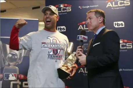  ?? ELSA GARRISON/GETTY VIA AP ?? Boston Red Sox manager Alex Cora celebrates with the William Harridge Trophy in the clubhouse after defeating the Houston Astros, 4-1, in the American League Championsh­ip Series last Thursday.