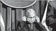  ?? MICAHEL A. MCCOY/THE NEW YORK TIMES ?? Dr. Anthony Fauci puts on a face mask during a coronaviru­s task force briefing last month in Washington.