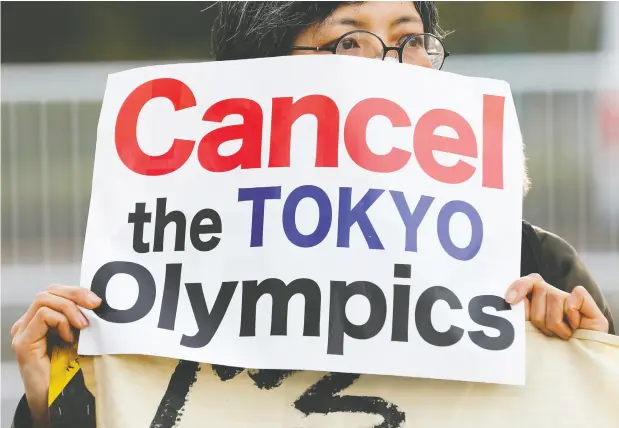  ?? KIM KYUNG-HOON / REUTERS ?? A woman holds a banner Friday in Tokyo during a rally in front of a building housing the organizing committee of the Olympic Games to demand the Games’ cancellati­on and to criticize sexist comments made by former organizing committee chief Yoshiro Mori.