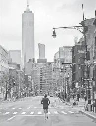  ?? BEBETO MATTHEWS/ AP ?? A lone jogger runs on a mostly empty Seventh Avenue in New York City on March 28.