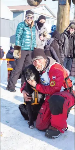  ?? Photo by Nils Hahn ?? RAD— Jason Mackey hugs his lead dog Rad, as Lance Mackey’s widow Seane Mackey looks on. Rad was Lance’s lead dog and led Lance Mackey’s last run in 2020 to Nome.