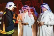  ?? BAHRAIN NEWS AGENCY ?? Sheikh Rashid bin Abdullah Al Khalifa (center), Bahrain’s interior minister, visits the scene of the pipeline explosion Saturday.