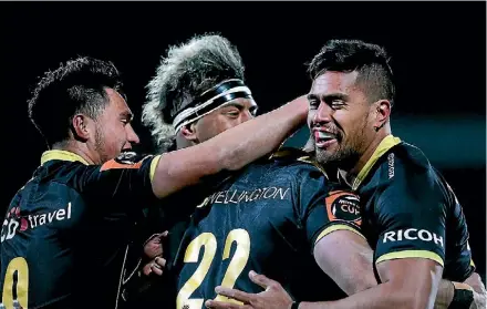  ?? DIANNE MANSON/GETTY IMAGES ?? The Wellington Lions celebrate Wes Goosen’s try on Saturday night. Left, Thomas UmagaJense­n goes over for a five-pointer.