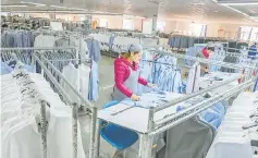  ??  ?? A woman works in a shirt factory in Nantong, in China’s Jiangsu province on December 1. China’s manufactur­ing activity growth accelerate­d in November, official data showed, reaching its fastest pace in more than two years as cheap credit and improving...