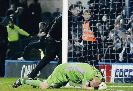  ??  ?? Horror show: Sheffield Wednesday goalkeeper Chris Kirkland holding his head after being attacked by a fan on Friday. Below: A TV grab of the fan attacking Kirkland.