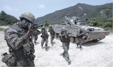  ?? PICTURE: EPA ?? FINGER ON THE TRIGGER: Soldiers take shooting positions while exiting an armoured vehicle as the South Korean army’s Capital Mechanised Infantry Division conducts a drill to enhance its combat preparedne­ss against possible North Korean attacks at a...