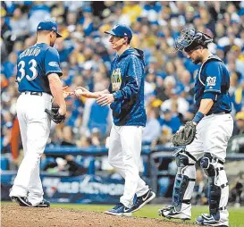  ??  ?? El mánager Craig Counsell le pide la bola al relevista Xavier Cedeño