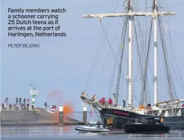  ?? PETER DEJONG ?? Family members watch a schooner carrying 25 Dutch teens as it arrives at the port of Harlingen, Netherland­s