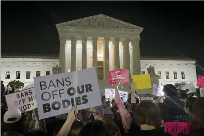  ?? NNA JOHNSON — THE ASSOCIATED PRESS ?? A crowd of people gather outside the Supreme Court on Monday night after a draft opinion circulated among Supreme Court justices suggesting that earlier this year a majority of them had thrown support behind overturnin­g the 1973case Roe v. Wade that legalized abortion nationwide.