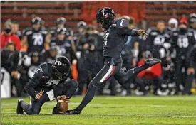  ?? AP ?? Cincinnati wide receiver Norman Love, left, holds as Cole Smith, a Middletown High School graduate, kicks the game winning field goal in the American Athletic Conference championsh­ip game against Tulsa on Saturday in Cincinnati. The Bearcats won 27-24.