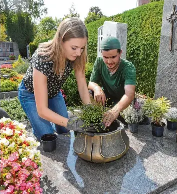  ?? Foto: Marcus Merk ?? Laura Gastl versuchte sich als Gärtnerin auf dem Diedorfer Friedhof. Gartenbaum­eister Daniel Birling greift ihr dabei hilfreich un ter die Arme.