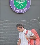  ??  ?? Roger Federer leaves the court after losing to Kevin Anderson in the Wimbledon quarterfin­als on Wednesday. BEN CURTIS/AP