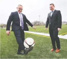  ?? DAN JANISSE ?? Terry Lyons, left, of the Windsor Essex Catholic board, shows some soccer skills Thursday with Egidio Mosca of the Caboto Soccer Club.