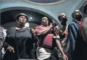  ?? Photos: Paul Botes ?? In good faith: Many worshipper­s have to be content with standing in the street (far left) when there is no space left in the Revelation Church of God, formerly the Jewish synagogue in Hillbrow (left).