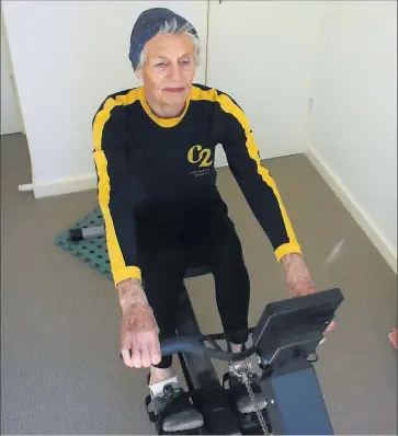  ??  ?? Solo effort: Anne Cresswell puts in the work with her home indoor rowing set-up.