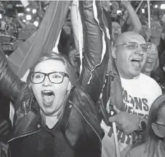  ?? FRANK AUGSTEIN, AP ?? Supporters of far- right leader Marine Le Pen celebrate during a rowdy gathering in Henin Beaumont during Sunday’s voting. Le Pen drew 22 percent of the vote, securing a place in the French presidenti­al runoff.