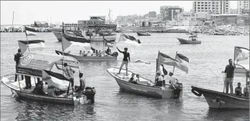  ?? Mahmud Hams
AFP/ Getty I mages ?? PALESTINIA­NS at the Gaza City seaport hold their f lag to show support for activists who were challengin­g Israel’s blockade. But an activist vessel was later turned away from Gaza and boarded by Israeli commandos.