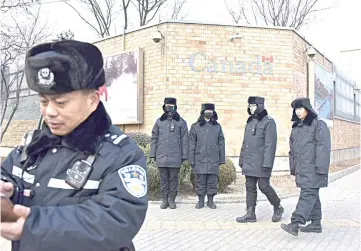  ??  ?? Chinese police officers patrol outside the Canadian embassy in Beijing. — AFP photo