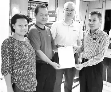  ??  ?? Ali Hassan (right) presents the birth certificat­e to Stephen as his wife (left) and Teng look on.