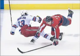  ?? NICK WASS — THE ASSOCIATED PRESS ?? Capitals wing T.J. Oshie, right, collides with the Rangers’ Mika Zibanejad during the third period of Washington’s overtime win over New York on Wednesday night.