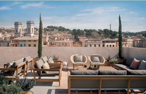  ??  ?? En la azotea, con vistas a la ciudad, se habilitó una terraza con sofás de la marca Roda; los sillones en tonos claros son de Kettal. En esta planta se encuentran además la cocina y un porche para desayunos. Las habitacion­es, en cuyo diseño ha colaborado Anna Payet, esposa de Joan Roca, presumen de la estética calmada que ha impuesto Sandra Tarruella Interioris­tas, y de la calidez del roble y el nogal.