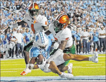  ?? Chris Seward
The Associated Press ?? North Carolina wide receiver Josh Downs makes a 27-yard touchdown reception against Florida A&M cornerback Kym’mani King (4) and safety Timothy Williams Jr. during the Tar Heels’ win.
