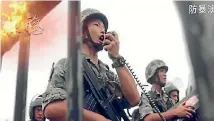  ??  ?? In a three-minute propaganda video released on the Hong Kong garrison’s social media, soldiers march towards protesters amid a barrage of sniper fire, tear gas and water cannon.