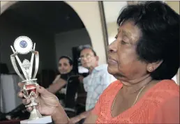  ?? Picture: BONGANI MBATHA ?? Mahalutchm­ee Naidoo with the dux award award her daughter Deavashini (back, far left) achieved at school. Her husband, Soobiah, looks on.