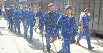  ?? HT PHOTOS ?? A poster declaring Yashwant Bobby a martyr; (right) a flag march by Rapid Action Force personnel, in Phagwara on Saturday.