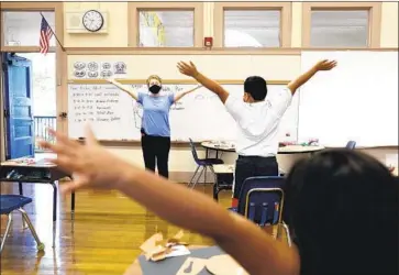  ?? Photograph­s by Christina House Los Angeles Times ?? NELLI TERGRIGORY­AN leads students in stretches during a summer program at Washington Elementary School in Pasadena. This year, 73% of California districts planned to provide summer enrichment programs.