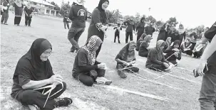  ??  ?? SAINGAN: Anggota KUNITA yang menyertai pertanding­an menganyam ketupat.