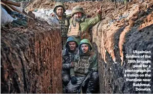  ?? LIBKOS ?? >Ukrainian soldiers of the 28th brigade pose for a photograph in a trench on the frontline near Bakhmut, Donetsk