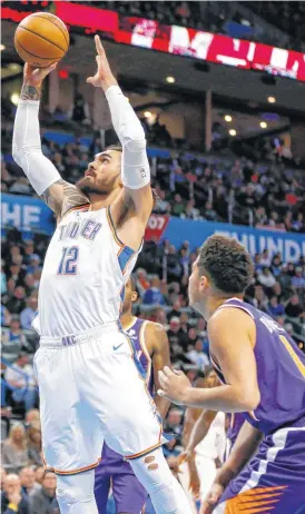  ?? [PHOTOS BY NATE BILLINGS, THE OKLAHOMAN] ?? Oklahoma City’s Steven Adams (12) shoots in front of Phoenix’s Devin Booker (1) during Monday’s game.