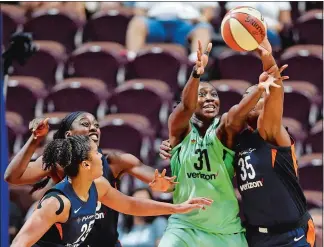  ?? SEAN D. ELLIOT/THE DAY ?? Connecticu­t Sun center Jonquel Jones, right, pokes the ball away from New York Liberty forward Tina Charles, center, as Sun teammates Alyssa Thomas (25) and Chiney Ogwumike, back, help on defense in the second half of Wednesday’s game at Mohegan Sun Arena.