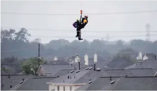  ?? REUTERSPIX ?? Rescue personnel, hanging from a military helicopter, save a stranded resident from floods caused by Harvey in east Houston on Tuesday.