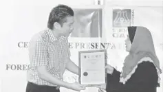  ??  ?? Khalidah presenting the Forest Management (Forest Plantation) certificat­e to James Ling.