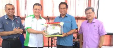  ??  ?? Chai presents a memento in the form of fresh water prawns to Dr Abdul Rahman (second right). Also seen are Ngab Dollah (left) and Wilson.