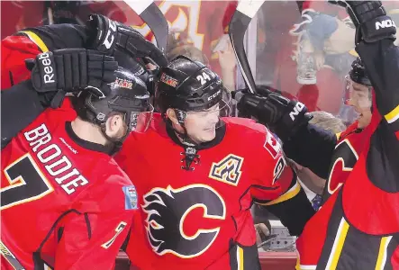 ?? ARYN TOOMBS/ CALGARY HERALD ?? Calgary players celebrate their second goal of the first period at the Scotiabank Saddledome on Thursday night. The goal put the Flames ahead 2- 0 en route to a 3- 1 win over the L. A. Kings and a berth in the NHL playoffs.