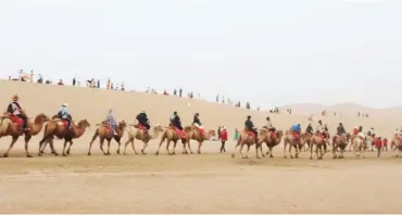  ?? ?? Fun-seekers navigating through the sand dunes of the Mingsha Mountain on camels