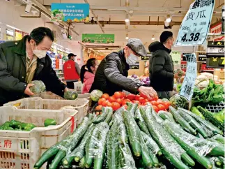  ??  ?? Clientes usan mascarilla­s en un supermerca­do.